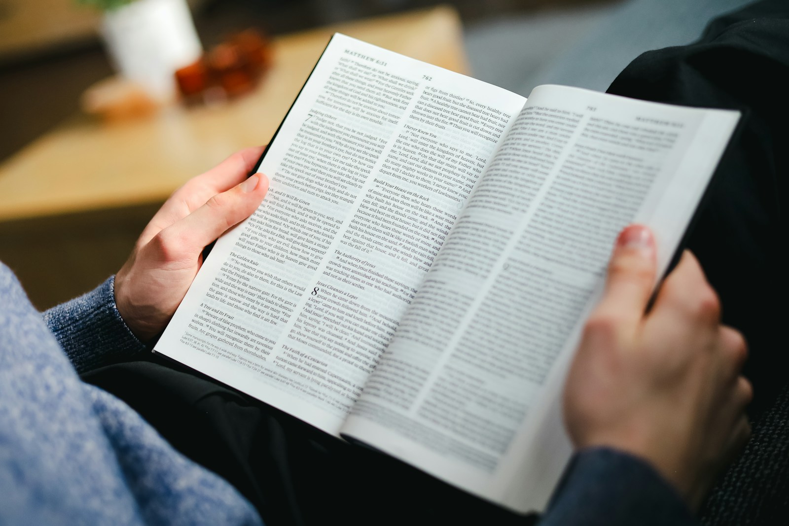 a person sitting on a couch reading a book