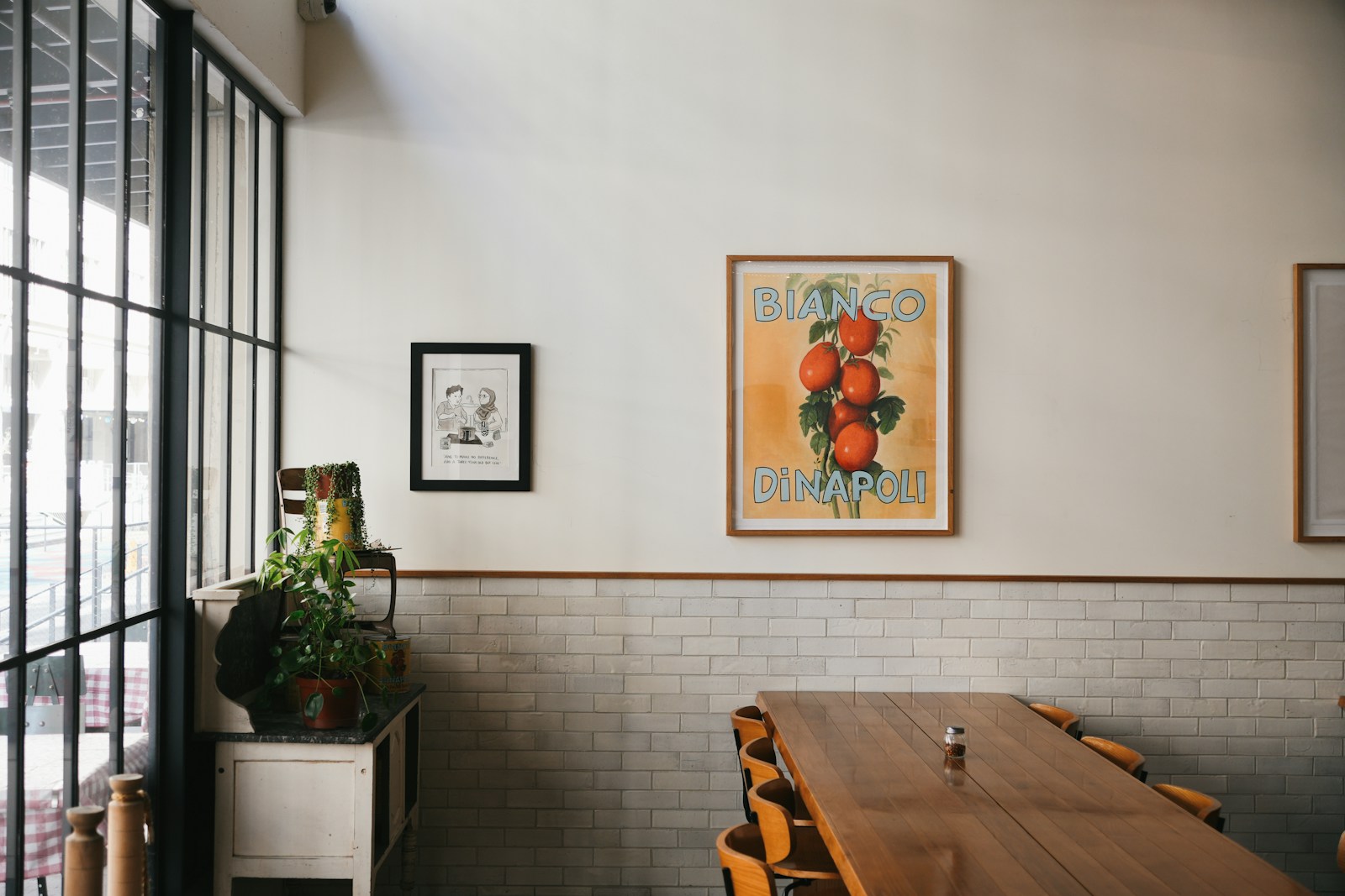 A table and chairs in a room with a picture on the wall